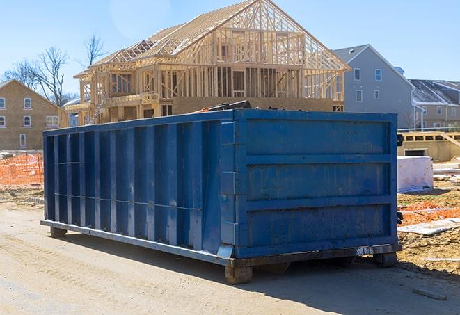 row of residential dumpsters parked on a street