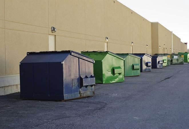 a waste management truck unloading into a construction dumpster in Riverton, KS